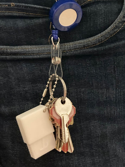 Keychain case for the Tubie Tech USB C Charger for Infinity Pumps in white hanging on a set of house keys