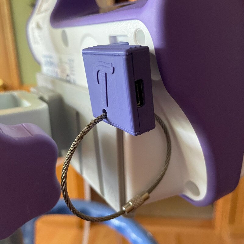 Close up of a USB-C charging adapter in a Kangaroo Omni pump with the included key chain hanging from the charging adapter