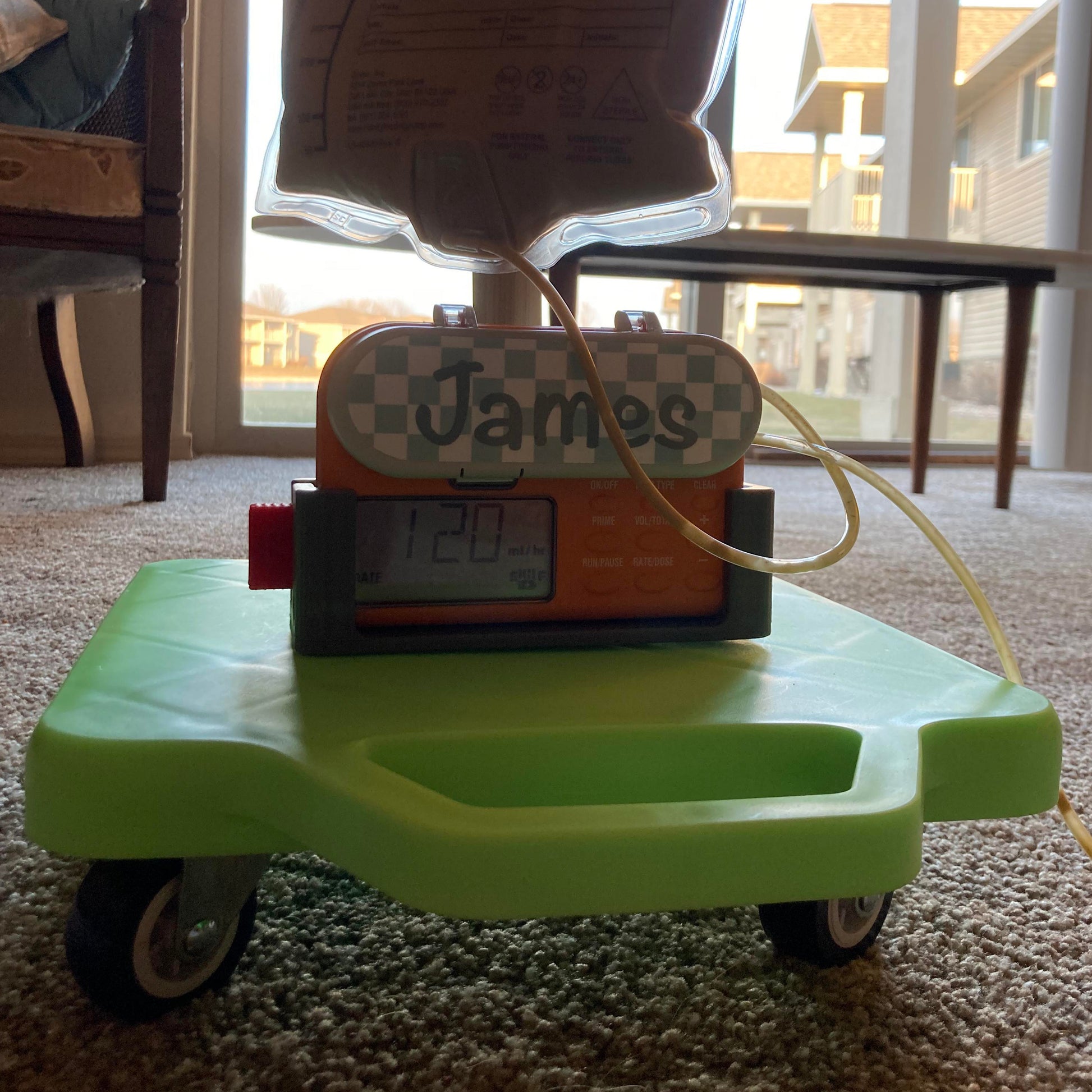 Infinity enteral feeding pump sitting on Tubie Cart scooter with the infinty pump holder